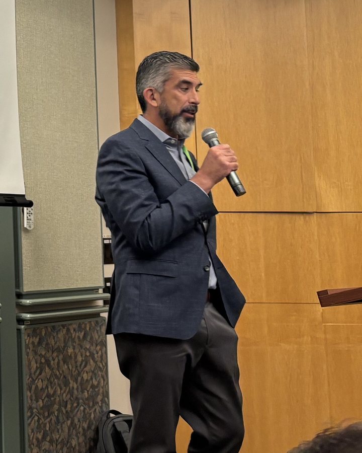 Tony Martin-Vegue speaking into a microphone at an ISACA event