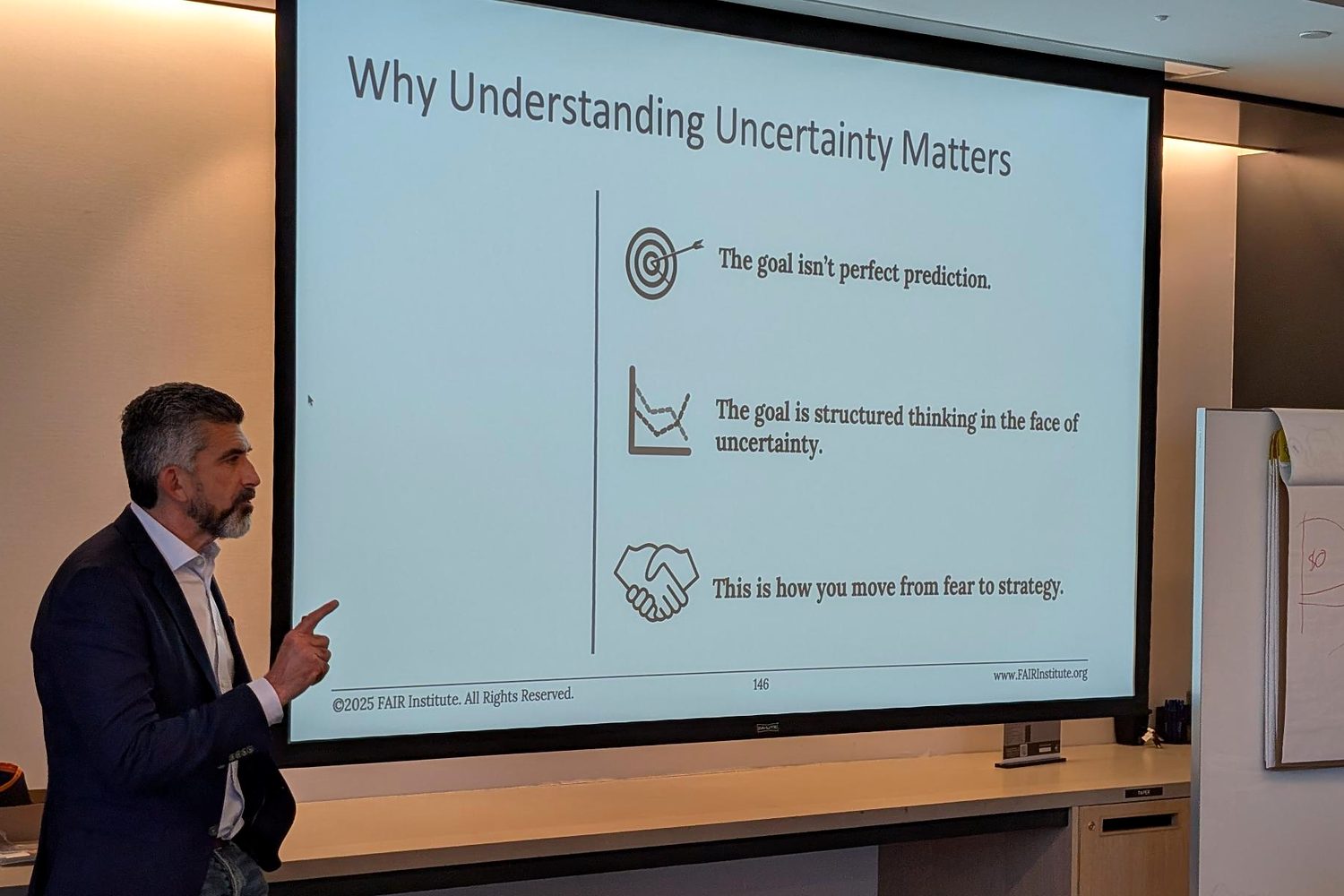 Tony Martin-Vegue teaching a class, pointing to a slide titled Why Understanding Uncertainty Matters